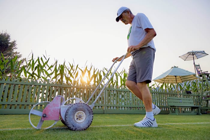 Mark Kuhn spends around 12 hours a week maintaining the grass tennis court in his side yard.